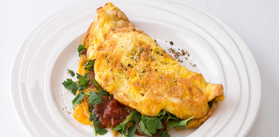 Austrálská snídaně  vaječná omeleta s rajčaty, sýrem a koriandrem ...